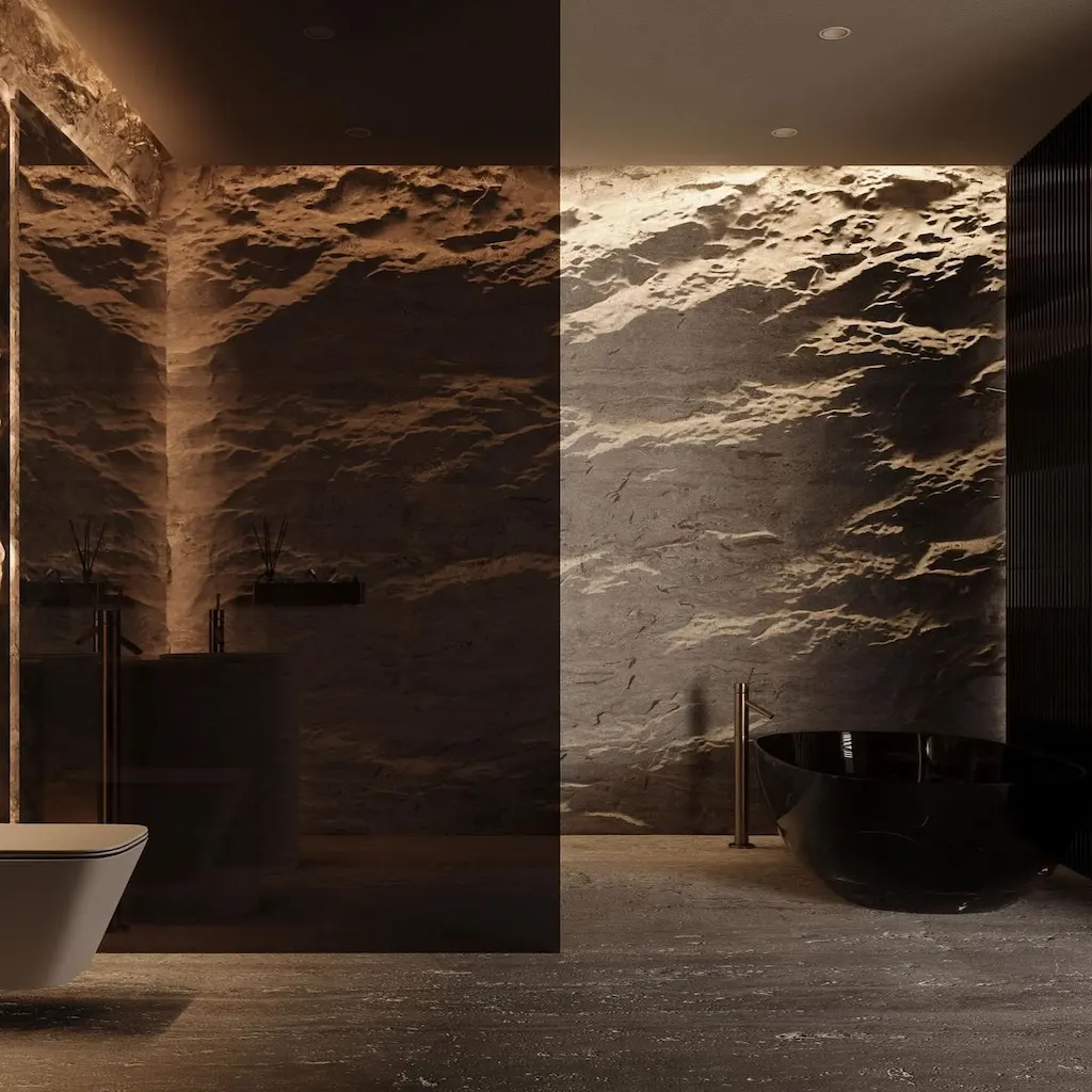 Salle de bain moderne avec murs en béton sculpté façon roche naturelle, baignoire noire et éclairage architectural