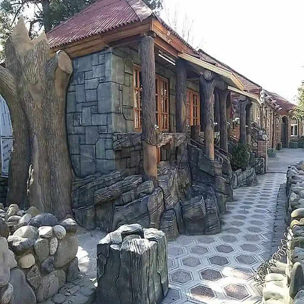 Façade en béton décoratif avec colonnes façon tronc d’arbre, murs effet pierre et sol pavé – Création Art Déco Béton