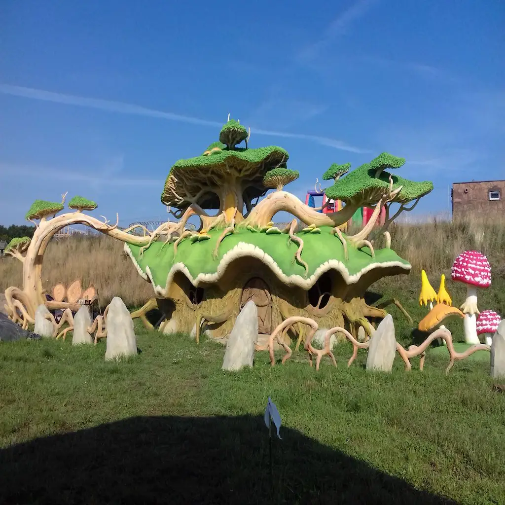 Maison thématique extérieure avec toiture en forme de feuillage, champignons géants et décor naturel en béton sculpté – Réalisation Art Déco Béton